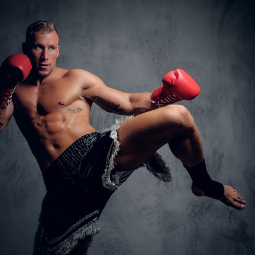 Male fighter in action. Male fighter in action. Leg kicking.